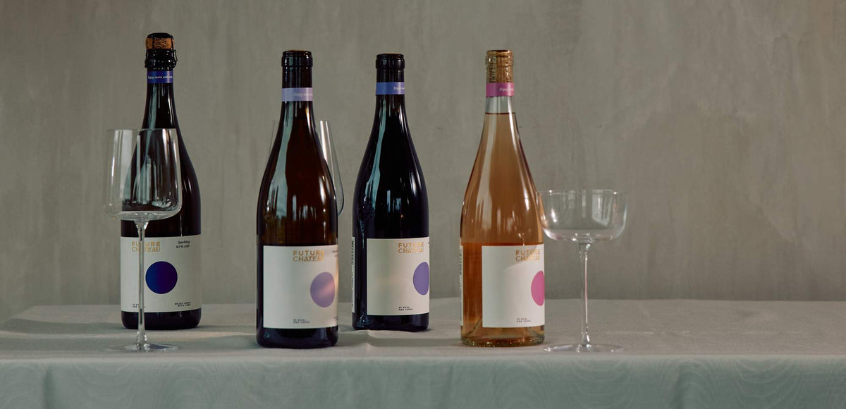 Four Future Château wines lined up on a table with wine glasses
